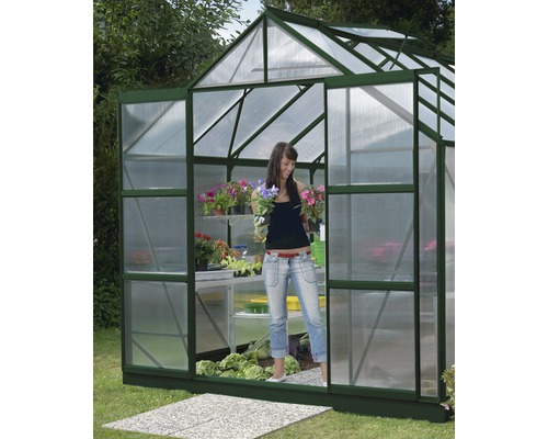 Extension de porte Vitavia sans verre pour Merkur, vert Serre avec des plantes et une femme dans le jardin.
