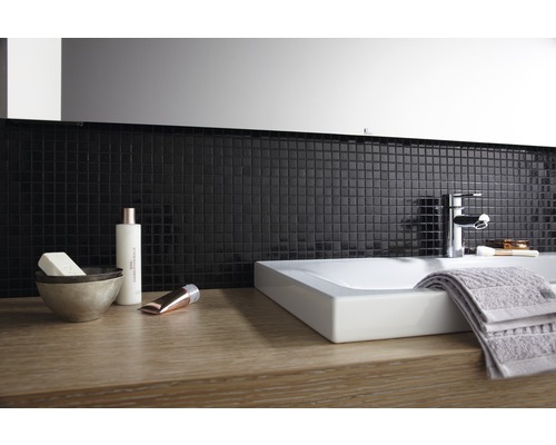 Salle de bains moderne avec lavabo à poser, robinet, serviette et carreaux de mosaïque
