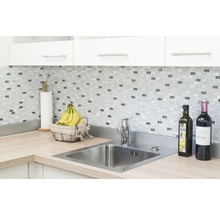 Scène de cuisine avec évier, robinet, carreaux de mosaïque et plan de travail