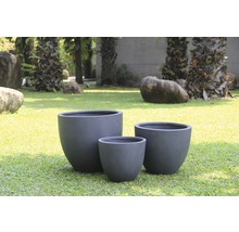 Drei Pflanzgefäße aus Faserzement in verschiedenen Größen im Garten.