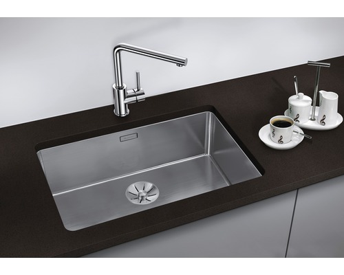 Évier avec robinet et égouttoir sur un plan de travail foncé