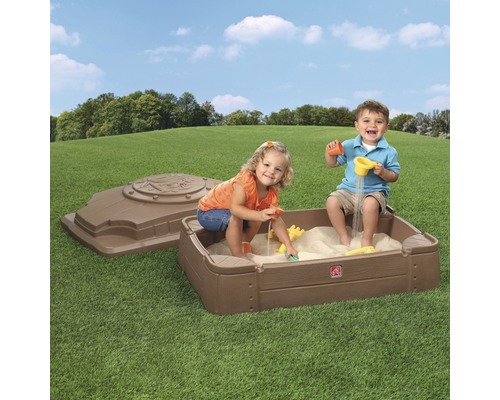 Sandkasten aus Kunststoff mit zwei spielenden Kindern und Deckel im Garten