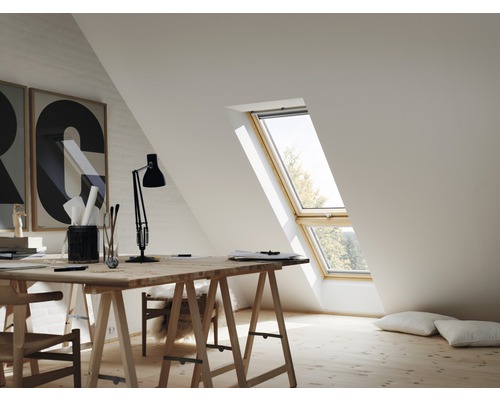 Heller Arbeitsbereich mit Dachfenster, Schreibtisch und Dekorationen in einem Dachgeschoss.