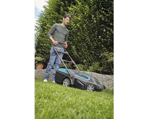 Mann bedient Rasenmäher im Garten.