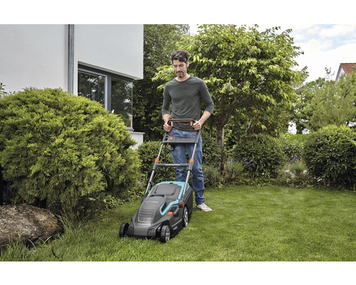 Ein Mann bedient einen Rasenmäher der Marke Gardena in einem Garten.