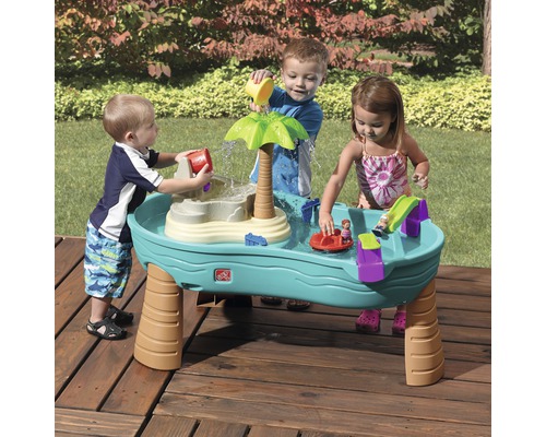 Kinder spielen mit einem Step2 Wasserspieltisch im Freien.