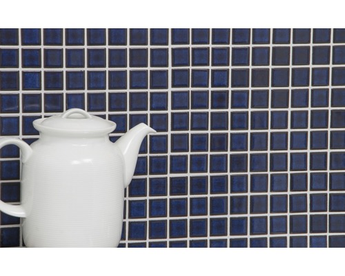 Mur de carreaux de mosaïque avec joints blancs et une théière blanche