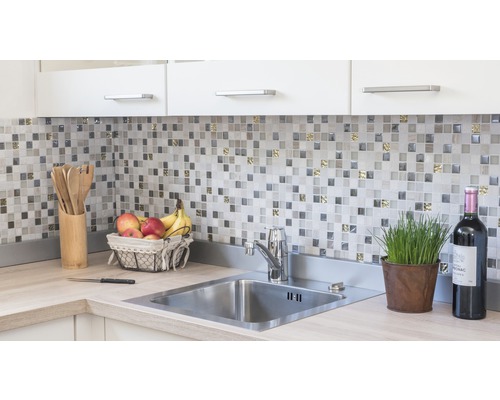 Küchenspüle mit Armatur, Mosaikfliesen und Küchenutensilien auf der Arbeitsplatte