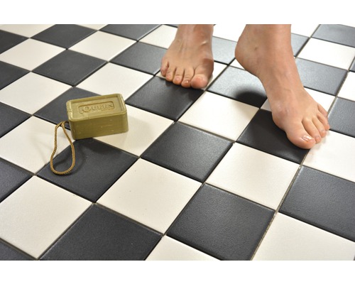 Badezimmerboden mit Schachbrettmuster, Olivenölseife und Füße