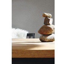 Tour de pierres décorative sur une table en bois devant un papier peint