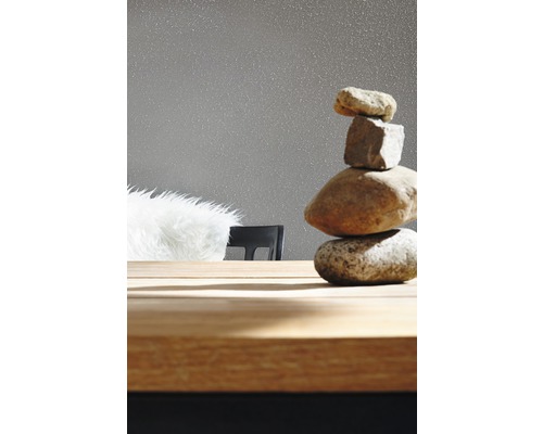 Tour de pierres décorative sur une table en bois devant un papier peint
