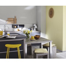 Cuisine lumineuse avec table à manger, chaises et appareils de cuisine.