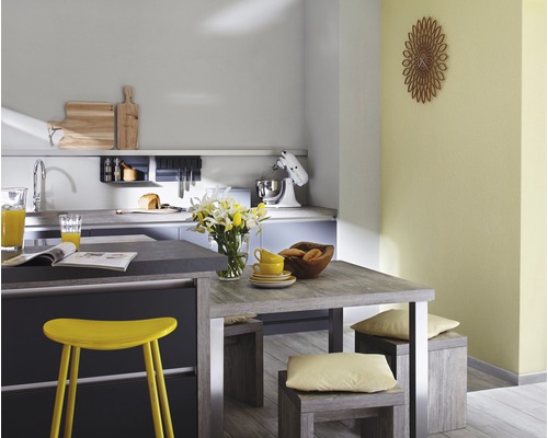 Cuisine lumineuse avec table à manger, chaises et appareils de cuisine.