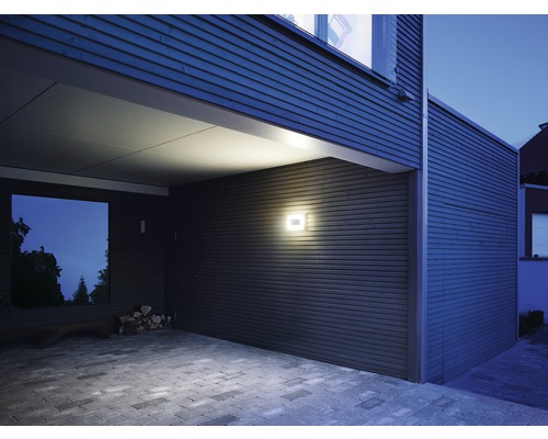 Extérieur d''une maison au design moderne avec éclairage extérieur et allée pavée