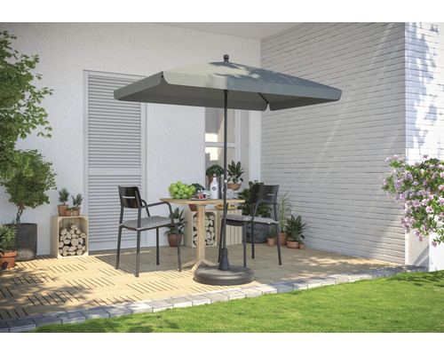 Szene mit quadratischem Sonnenschirm, Tisch und zwei Stühlen auf einer Terrasse