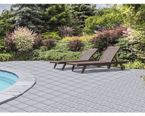 Jardin avec deux chaises longues et dalles de terrasse grises