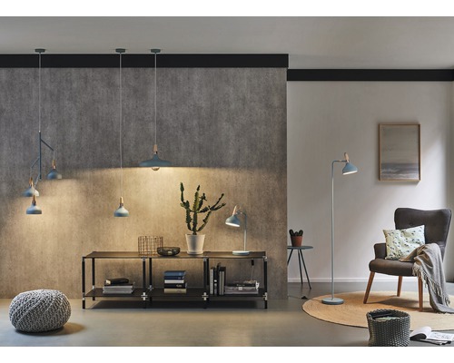 Salon avec suspensions, lampe de table, lampadaire, fauteuil et bibliothèque dans un style moderne et lumineux