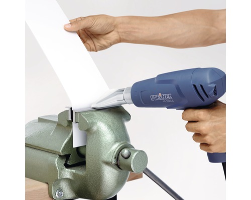 Eine Heißluftpistole wird verwendet, um ein Werkstück in einem Schraubstock zu bearbeiten.