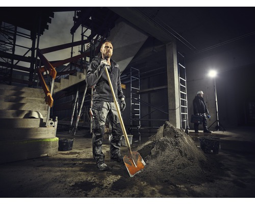 Ouvrier du bâtiment avec une pelle sur un chantier