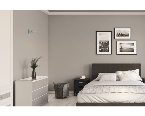 Chambre moderne avec lit, commode et un anneau porte-serviettes fixé au mur