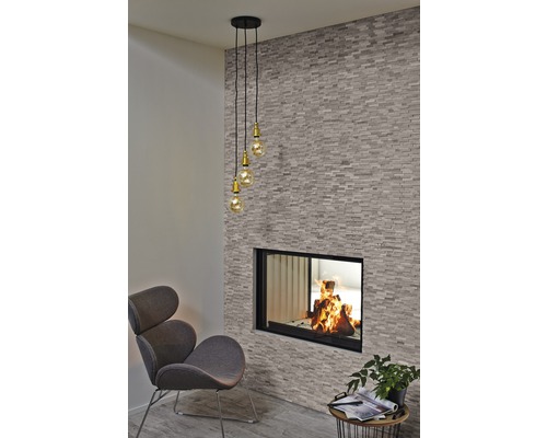 Wohnzimmer mit Kamin, Sessel und Pendelleuchte