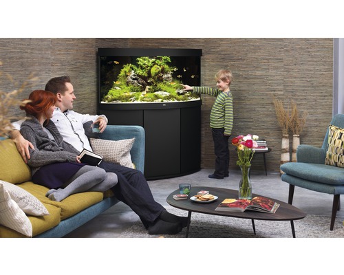 Familie betrachtet Aquarium im Wohnzimmer