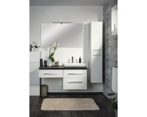 Badezimmer mit Waschtisch, Spiegel, Hochschrank und Badteppich für eine helle und freundliche Atmosphäre