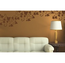 Salon décoratif avec sticker mural au-dessus d''un canapé et une lampe sur une table