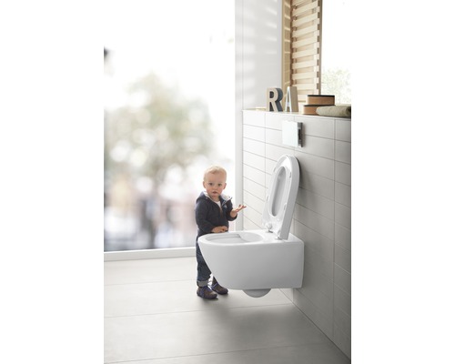 WC suspendu dans une salle de bains avec un enfant devant