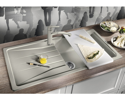 Évier de cuisine avec robinet et planche à découper sur un plan de travail