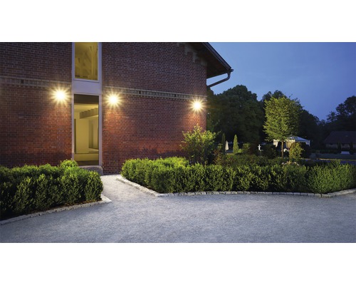 Beleuchtetes Gebäude mit Gartenanlage und gepflastertem Weg