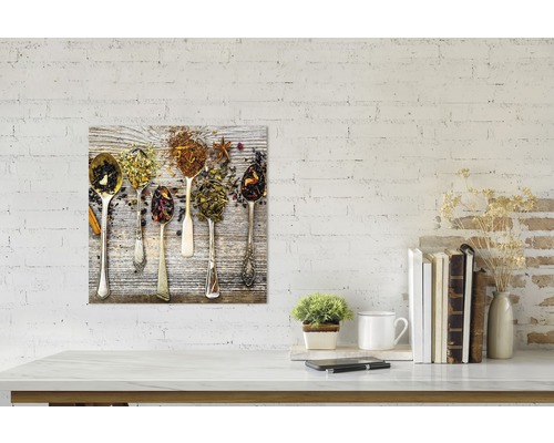 Tableau décoratif avec différentes sortes de thé dans des cuillères sur fond en bois