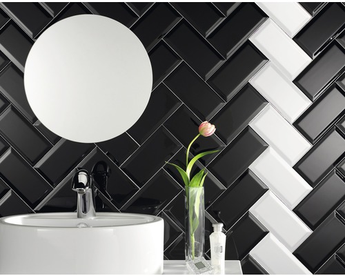 Badezimmer mit Waschbecken, Spiegel und schwarz-weißen Ziegeln im Fischgrätenmuster