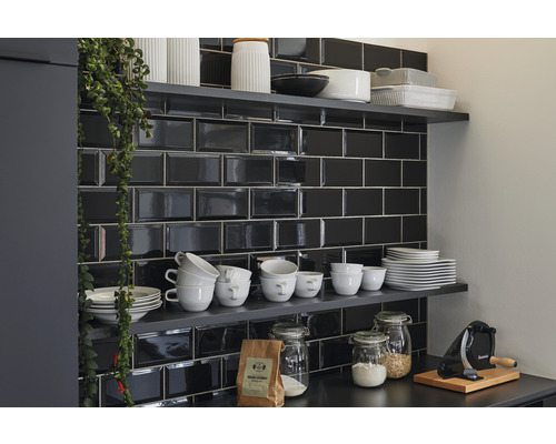 Küchenszene mit schwarzen Metrofliesen, Regalen und Küchenutensilien