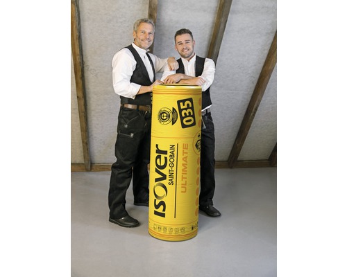 Deux hommes posent à côté d''un rouleau de laine de verre Isover Saint-Gobain.