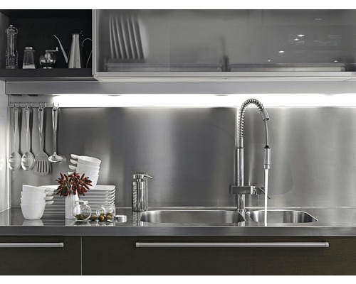 Küchenspüle mit Armatur, Geschirr und Küchenutensilien auf der Arbeitsplatte