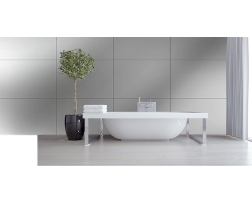 Helles Badezimmer mit freistehender Badewanne, Zimmerpflanze und Handtüchern