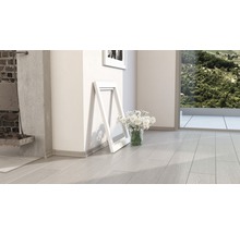 Pièce claire avec parquet, cadre photo et fleurs dans un vase