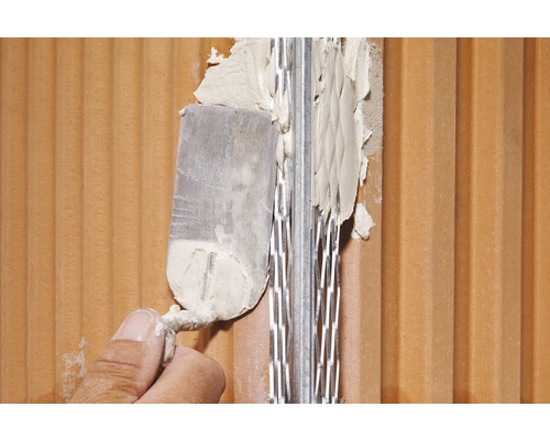 Application de mortier sur un mur de briques avec une spatule