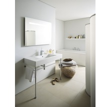 Salle de bain lumineuse avec lavabo sur pieds, miroir, baignoire et décoration