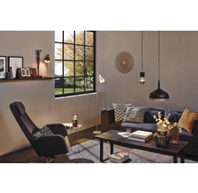 Salon avec canapé, fauteuil, table, lampadaire, suspensions et horloge murale décorative