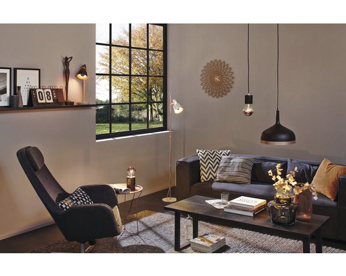 Salon avec canapé, fauteuil, table, lampadaire, suspensions et horloge murale décorative