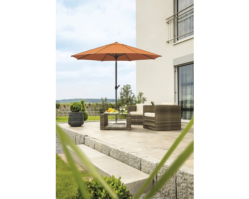 Terrasse mit Gartenschirm, Gartenmöbeln und Steintreppen vor einem Haus