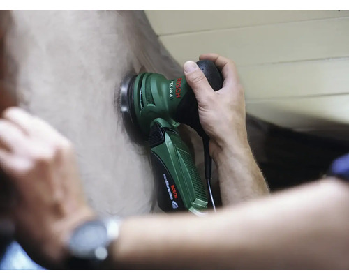 Eine Person verwendet einen Exzenterschleifer der Marke Bosch zum Schleifen einer Oberfläche.