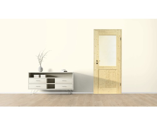Zimmertür aus Holz mit Glaseinsatz neben einer Kommode in einem hellen Raum.