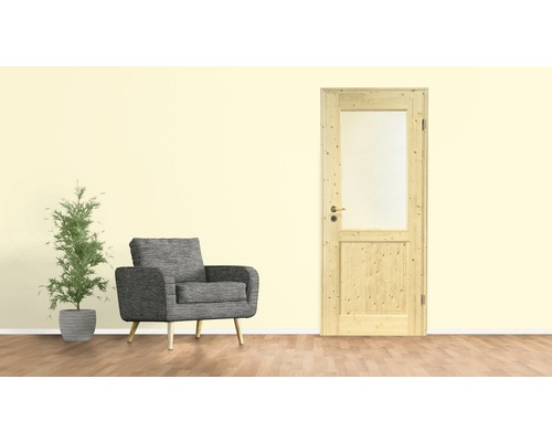 Wohnzimmer mit Holztür, Sessel und Topfpflanze.