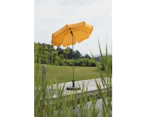 Gelber Gartenschirm auf einer Terrasse mit Rasenfläche