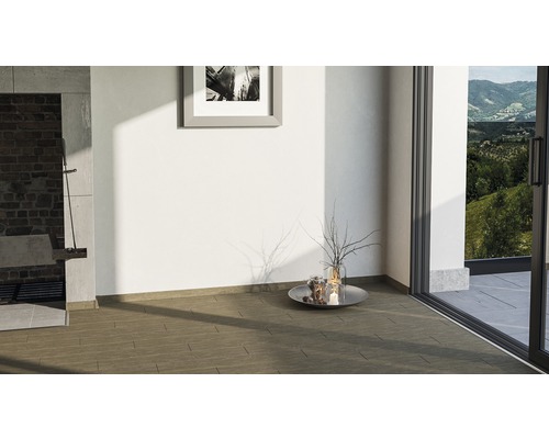 Pièce lumineuse avec carrelage, tableau au mur et vue sur la verdure