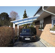 Un carport en aluminium avec une voiture devant.