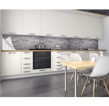 Cuisine moderne avec armoires blanches, plan de travail en bois et mur en pierre grise